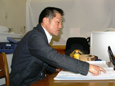 地図上の自宅の位置と原発の位置を指し示す高橋さん